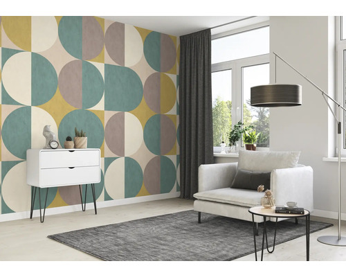 Wohnzimmer mit geometrischer Tapete, Sessel, Teppich und Kommode