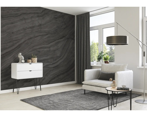 Wohnzimmer mit grauer Tapete in Marmoroptik, Sessel, Stehlampe und Kommode