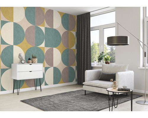 Wohnzimmer mit gemusterter Tapete, Sessel und weißem Schrank