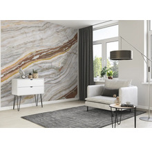 Wohnzimmer mit Marmortapete, Sessel, Teppich und Kommode
