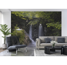 Wohnraum mit Fototapete eines Wasserfalls in einer grünen Landschaft.