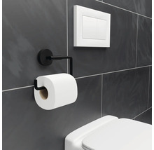 Toilettenpapierhalter aus Metall mit Toilettenpapierrolle neben einer Toilettenspülung