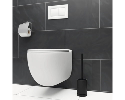 Wandhängendes WC mit Toilettenpapierhalter und Bürstengarnitur vor grauer Wand