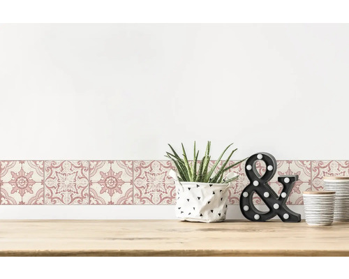 Wandbordüre mit floralem Muster auf einem Tisch mit Dekorationen.