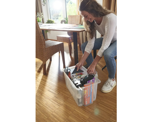 Frau verstaut Werkzeuge und Materialien in einer transparenten Aufbewahrungsbox.