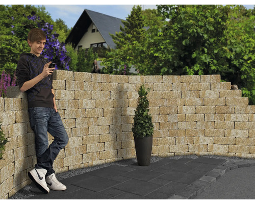 Gestaltungsidee für einen Garten mit Mauersteinen, Bodenplatten und einer Person