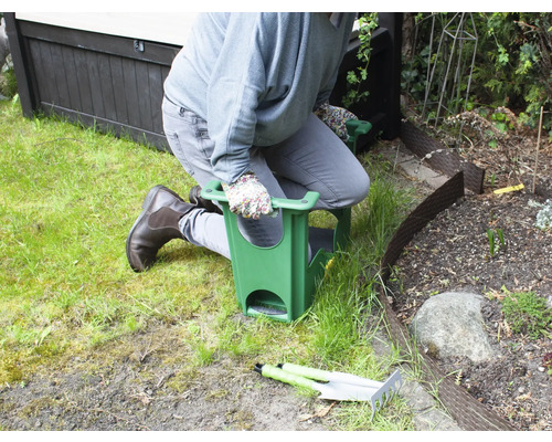 Person kniet auf einem Gartenhocker bei der Gartenarbeit.