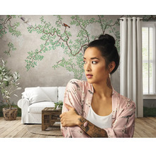 Wohnzimmer mit floraler Tapete, Sofa und Frau mit Morgenmantel