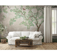 Wohnzimmer mit Sofa vor einer Wandtapete mit Baum- und Vogelmuster