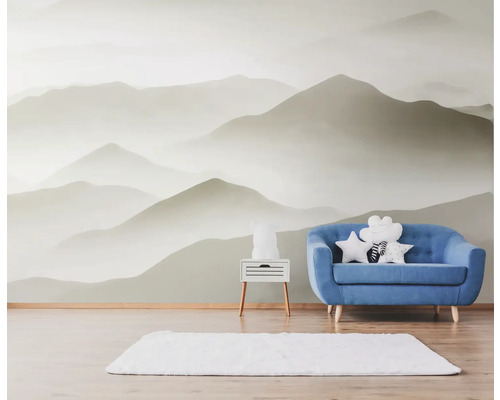 Helles Zimmer mit Bergtapete, blauem Sofa und weißem Teppich
