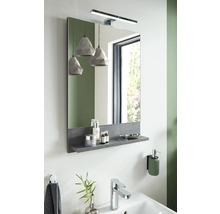 Badezimmerszene mit Spiegel, Ablage, Lampe und Waschbecken