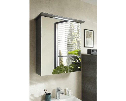 Badezimmer mit Spiegelschrank mit Beleuchtung über einem Waschbecken