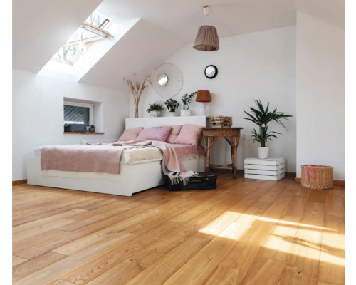 Helles Schlafzimmer im Dachgeschoss mit Holzboden, Bett und Dachfenster