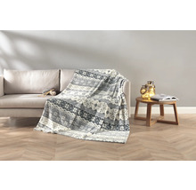 Wohnzimmer-Szene mit Sofa, Wolldecke mit Muster, Beistelltisch mit Buch und Dekoration