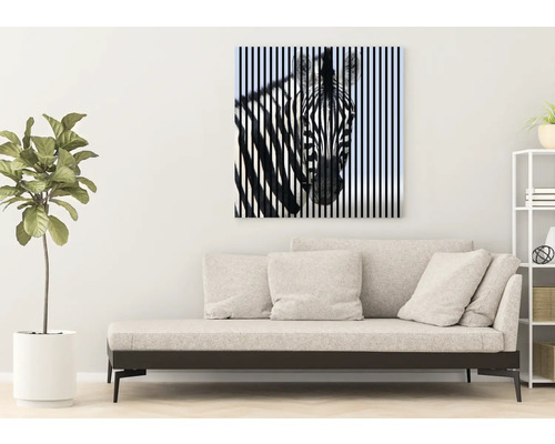 Dekoratives Leinwandbild mit Zebra-Motiv über einem Sofa in einem hellen Wohnraum.