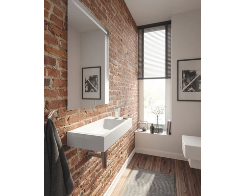 Badezimmer mit Waschbecken, Spiegel und Backsteinwand