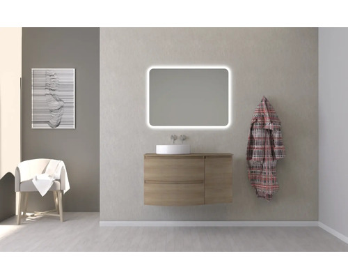 Badezimmer mit Waschtisch, beleuchtetem Spiegel, Stuhl und Bademantel