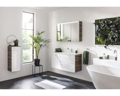 Modernes Badezimmer mit Waschtisch, Spiegelschrank, Hängeschrank, Badewanne und Pflanzen für eine helle und freundliche Atmosphäre.