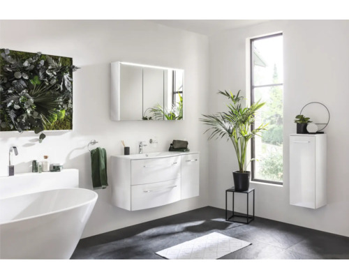 Badezimmer mit freistehender Badewanne, Waschtisch mit Unterschrank, Spiegelschrank, Hochschrank und Wanddekoration aus Pflanzen