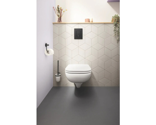 Modernes Badezimmer mit wandhängendem WC, Betätigungsplatte und geometrischen Fliesen