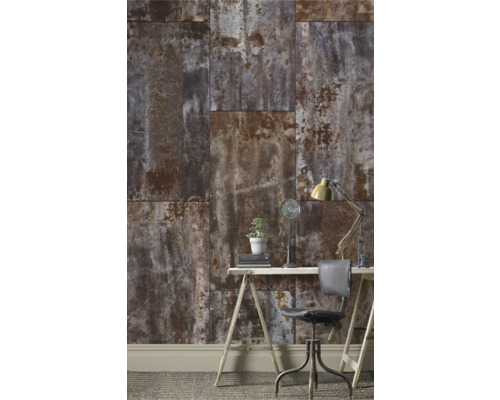 Ein Arbeitszimmer mit einer Wand aus Paneelen in Rostoptik, einem Schreibtisch, einem Stuhl und einer Lampe.