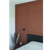 Schlafzimmer mit Wandpaneelen, Bett, Nachttisch und Wandleuchte