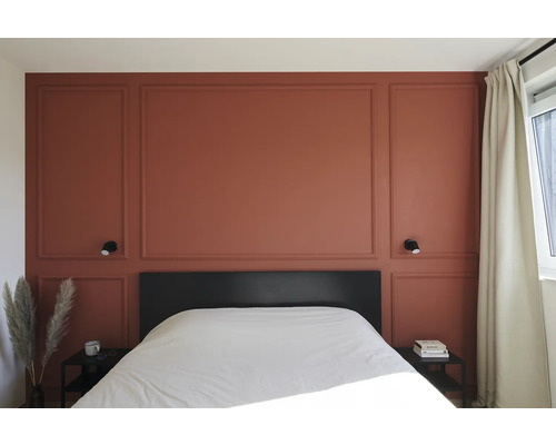 Schlafzimmer mit Wandpaneelen, Bett und Nachttischen.