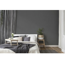 Schlafzimmer mit Bett, Nachttisch und Vorhängen für eine gemütliche Atmosphäre