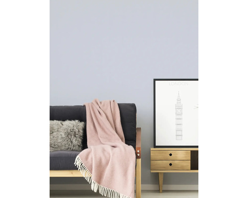 Wohnzimmer mit Schlafsofa, Kissen, Decke und Sideboard mit London-Bild