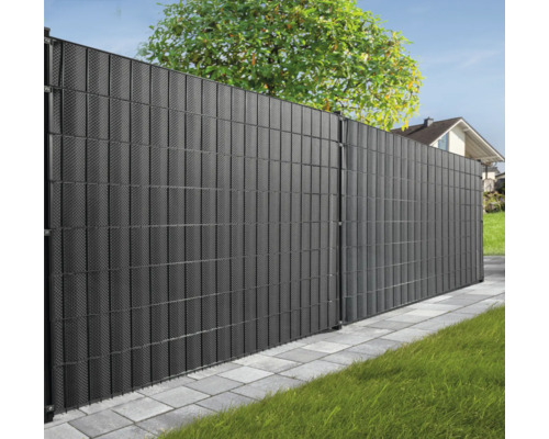 Dunkler Gartenzaun aus Kunststoff mit Struktur vor Bäumen