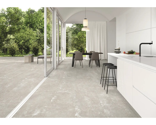 Heller Raum mit Esstisch, Küche und großformatigen Bodenfliesen
