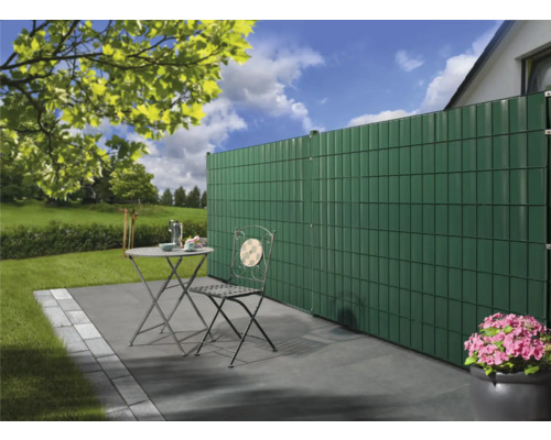 Gartenszene mit Sichtschutzzaun, Gartentisch und Stuhl auf einer Terrasse