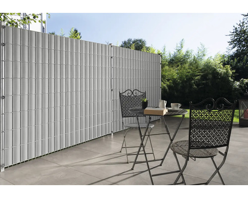 Sichtschutzzaun aus Kunststoff mit Tisch und Stühlen auf einer Terrasse