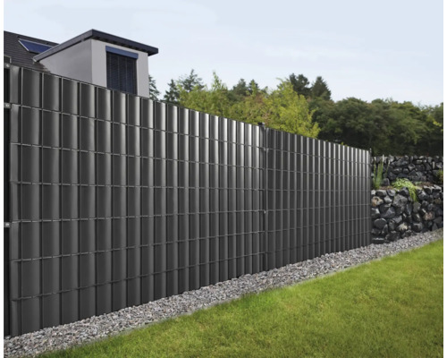 Außenaufnahme eines Gartens mit einem grauen Sichtschutzzaun.