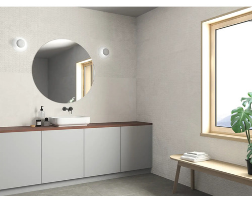 Modernes Badezimmer mit rundem Spiegel, Waschbecken und Fenster für ein helles Ambiente