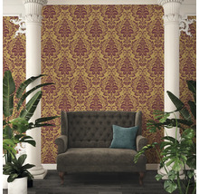 Raumansicht mit goldfarbener Tapete mit floralem Muster, Sofa und Pflanzen