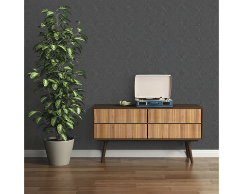 Einrichtungsbeispiel mit Kommode, Schallplattenspieler und Zimmerpflanze vor einer gemusterten Tapete.