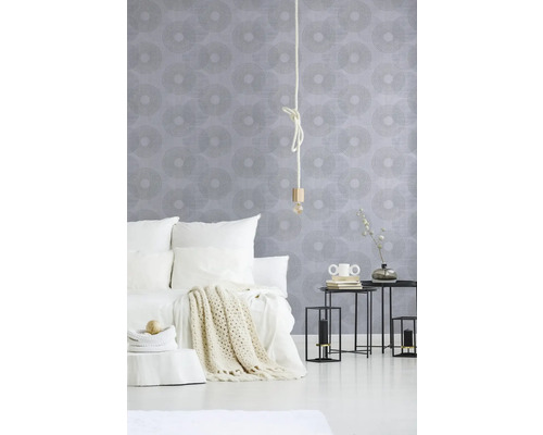 Schlafzimmer mit Bett, Nachttischen und gemusterter Tapete