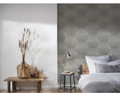 Schlafzimmer mit geometrischer Tapete, Holzhocker und Dekorationen