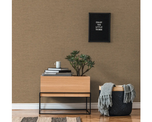 Nahaufnahme einer strukturierten Tapete in einem Wohnzimmer mit einem kleinen Tisch, einer Pflanze und dekorativen Elementen