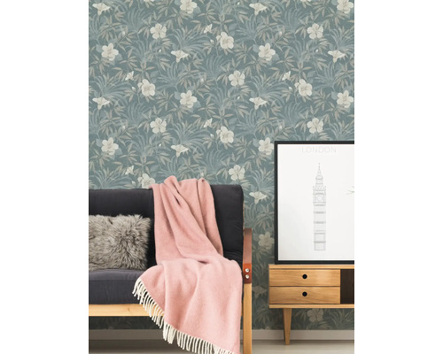 Wohnraum mit floral gemusterter Tapete, Sofa, Decke und Beistelltisch mit London-Motiv