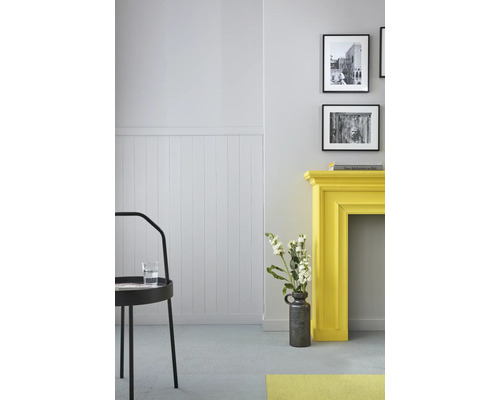 Heller Raum mit Stuhl, gelbem Kaminsims, Wandpaneelen und Dekorationen