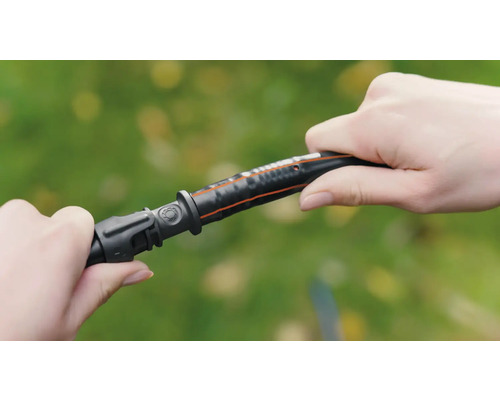 Zwei Hände verbinden einen Gartenschlauch mit einem Verbinder.