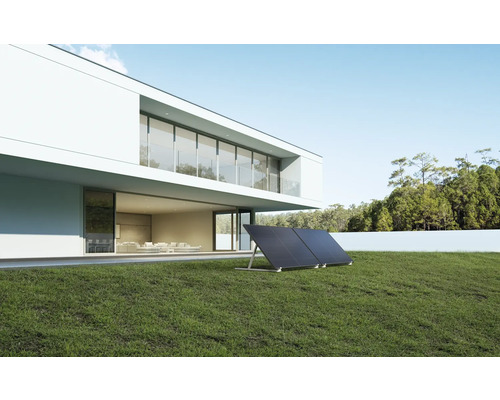 Zwei Solarmodule auf einer grünen Wiese vor einem Haus