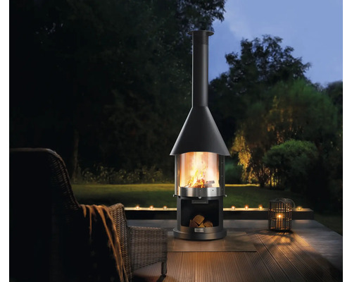 Gartenszene mit Kaminofen, Holzscheiten und Kerzen