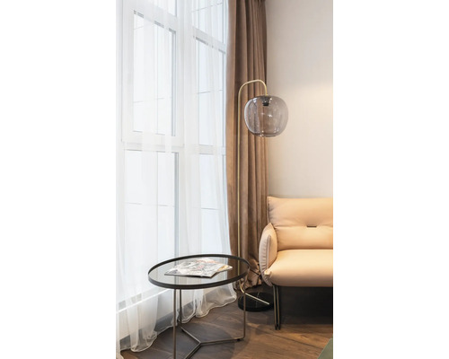 Wohnzimmer mit Stehlampe, Tisch und Sessel