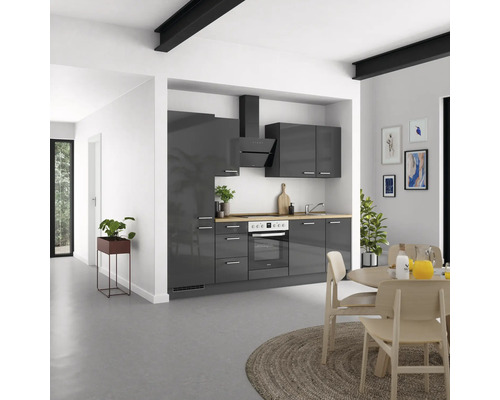 Moderne Küche mit grauen Schränken, Dunstabzugshaube und Holzarbeitsplatte in einem hellen Raum.