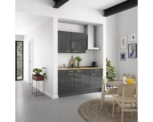 Moderne Küche mit grauen Schränken, Holzarbeitsplatte und Esstisch im hellen Raum.