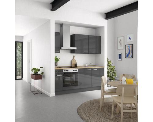 Moderne Küche mit grauen Schränken, Dunstabzugshaube und Holzarbeitsplatte in einem hellen Raum.