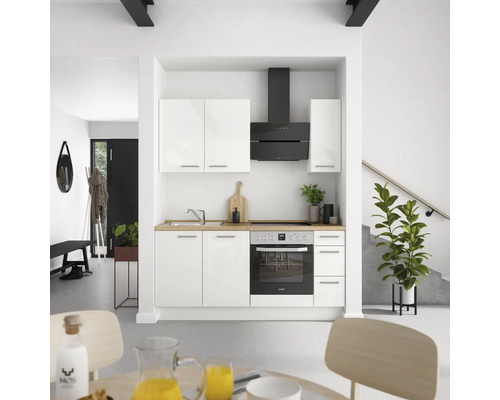 Helle Küche mit weißen Schränken, Dunstabzugshaube und Elektroherd in einem modernen Haus.